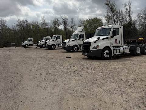 Row of white commercial truck cabs for on-site fleet washing